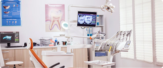 Dental office interior featuring examination chair, dental equipment, and monitor displaying images, illustrating senior dental care options.