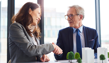 Business professionals shaking hands, symbolizing partnership and business continuity, relevant to life insurance solutions for buy-sell planning.