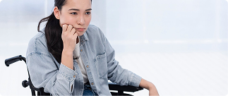 Woman in wheelchair contemplating disability insurance options, reflecting the importance of income protection for professionals.
