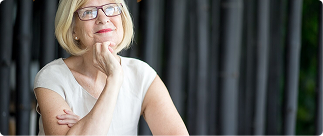 Thoughtful senior woman in glasses, contemplating dental and vision insurance options for seniors, emphasizing the importance of coverage as people age.