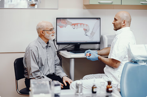 Senior man consulting with dentist in dental office, discussing treatment options with visual aid on screen, emphasizing importance of dental care for seniors.