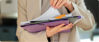 Person reviewing documents in a folder, symbolizing the process of understanding disability insurance options and underwriting requirements.