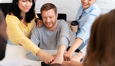 Team collaboration and engagement during a business meeting, showcasing employees celebrating teamwork and support in a professional setting.