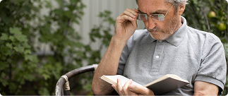 Senior man reading a book outdoors, illustrating the importance of understanding disability insurance options for professionals.