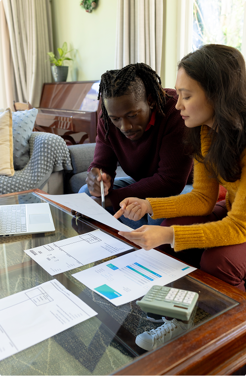 Couple reviewing financial documents and calculations at home, discussing income qualification for health insurance subsidies.