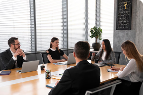 Business meeting with diverse professionals discussing employee benefit solutions and group insurance strategies at a modern conference table.