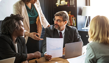 Business meeting with diverse professionals discussing key man insurance and financial strategies, highlighting collaboration and planning for business continuity.