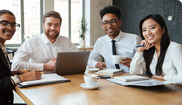 Licensed health insurance professionals collaborating at a table with a laptop, notepads, and coffee, emphasizing personalized assistance and plan customization for private health insurance options.