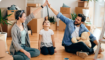 Family celebrating together in a home with moving boxes, emphasizing the importance of life insurance for family protection and financial security.
