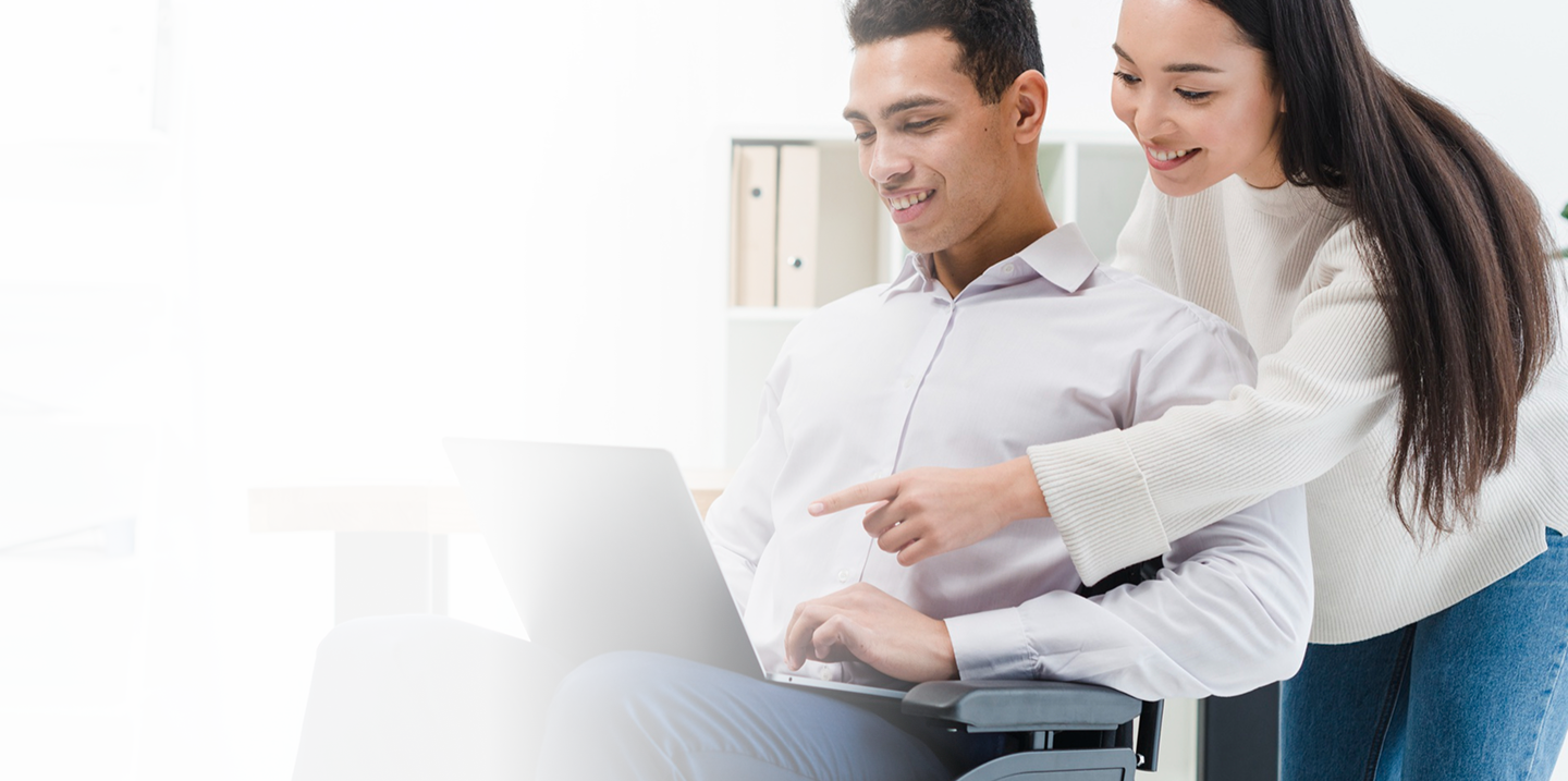 Man in wheelchair and woman discussing options on laptop, representing individual disability insurance solutions for high-earning professionals and business owners.