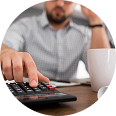 Person using a calculator while analyzing employee benefit solutions and cost-saving strategies.