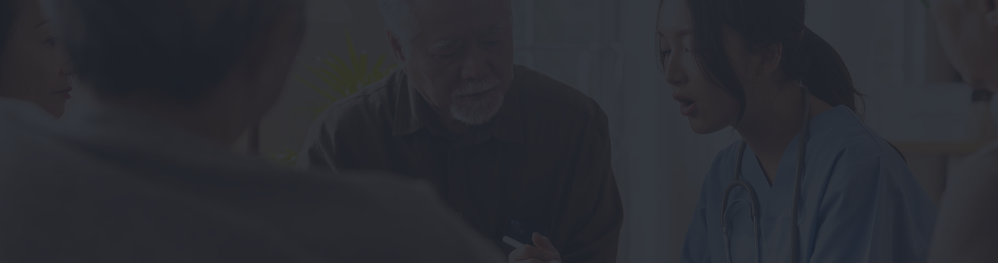 Older man consulting with a healthcare professional in a medical setting, discussing Medicare options and personalized care.