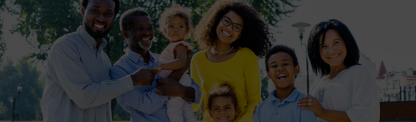 Diverse family smiling together outdoors, representing community and support for affordable health insurance options through ACA plans.