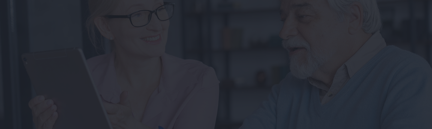 Senior woman smiling and showing tablet to older man, discussing auto insurance options at Amerus Financial.