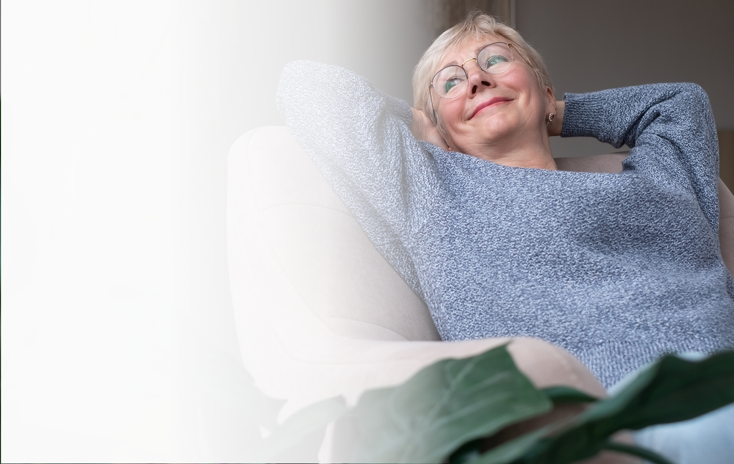 Senior woman relaxing in a cozy chair, smiling, representing peace of mind and security in retirement, aligning with Amerus Financial's focus on fixed and indexed annuities for guaranteed income.