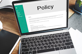 Laptop displaying a policy document, emphasizing the importance of proper policy design and funding in Indexed Universal Life insurance.