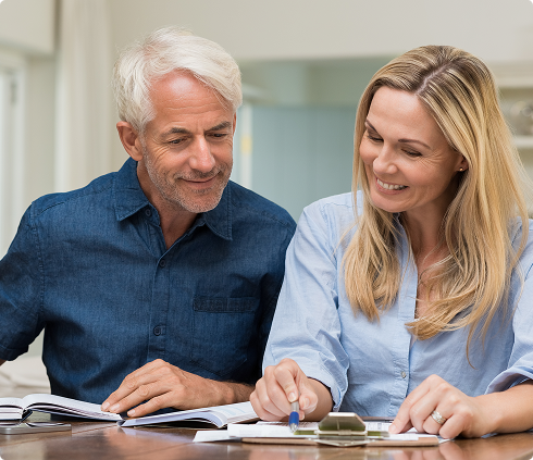 Couple discussing retirement planning with documents and calculator, emphasizing financial guidance and secure retirement solutions.