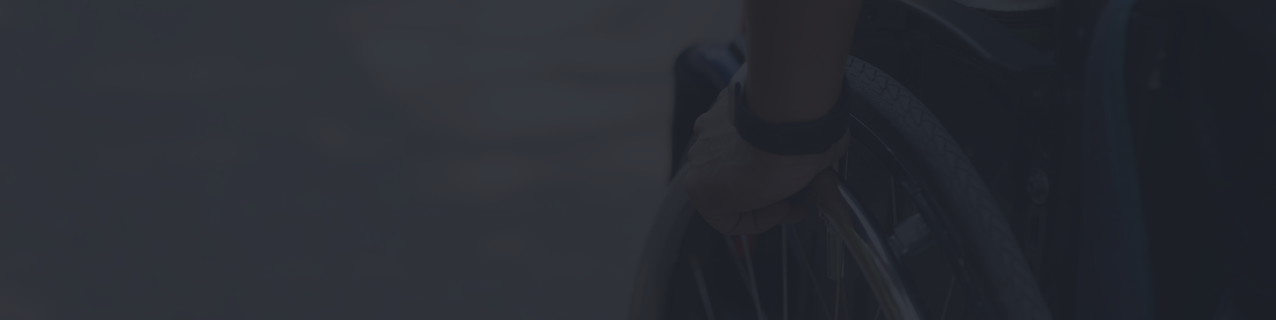 Person holding a wheelchair wheel, symbolizing the importance of individual disability insurance for income protection.