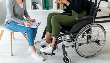 Person in a wheelchair consulting with an advisor, emphasizing disability insurance and personal insurance options.