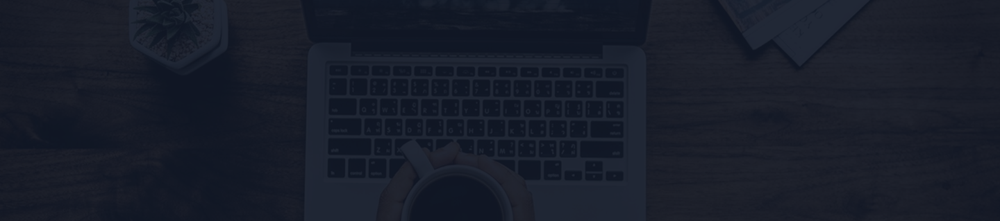 Laptop on wooden desk with coffee cup and succulent plant, reflecting a workspace for financial planning and insurance insights.