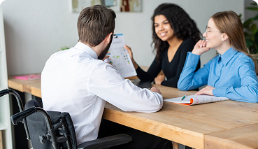Business insurance consultation with diverse professionals discussing employee benefits and coverage options at a table.