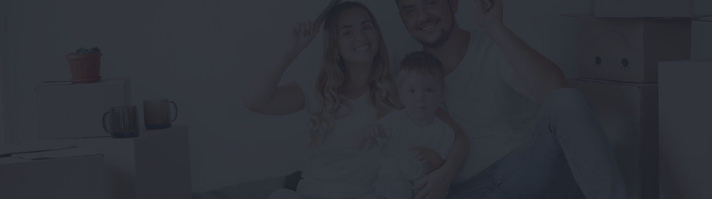 Family sitting together with moving boxes, smiling and celebrating new beginnings, representing the importance of life insurance for protecting loved ones.