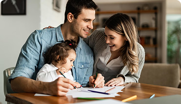 Family engaged in a creative activity at home, emphasizing the importance of life insurance for protecting loved ones and ensuring financial security.
